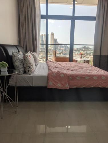 a bed in a room with a large window at Dar es Salaam Marina Apartments in Dar es Salaam