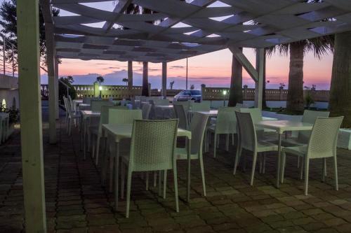 a row of tables and chairs under a roof at Holiday Affittacamere in Corigliano Calabro
