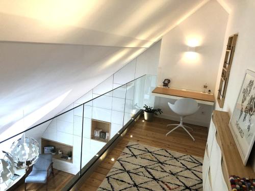 a staircase with glass walls and a chair in a room at Duplex moderne vue MontBlanc, Cœur de Chamonix in Chamonix-Mont-Blanc