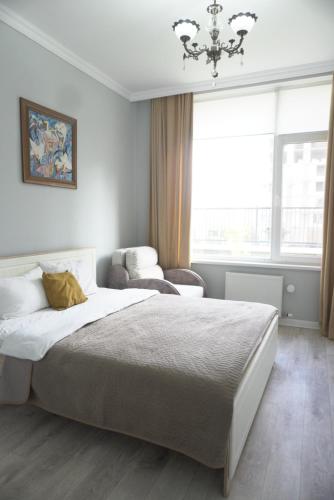 ein Schlafzimmer mit einem großen Bett und einem Kronleuchter in der Unterkunft Home Apart in Astana