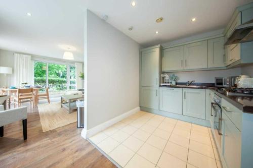 a kitchen with blue cabinets and a dining room at Stunning and modern 2 bedroom apartment in Lucan in Lucan