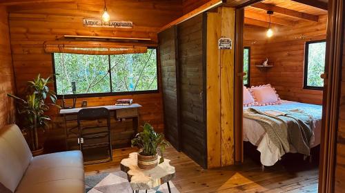 a bedroom in a log cabin with a bed and a sink at Casa Tikkun in Medellín