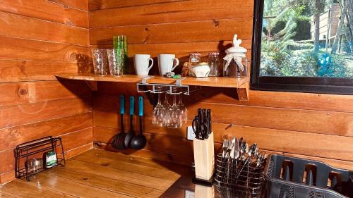 a kitchen with a wooden wall with utensils at Casa Tikkun in Medellín