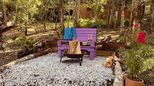 a purple bench sitting in a garden with plants at Casa Tikkun in Medellín