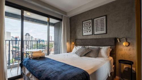 a bedroom with a bed and a large window at Studios modernos e completos ao lado da estação Vila Mariana in Sao Paulo