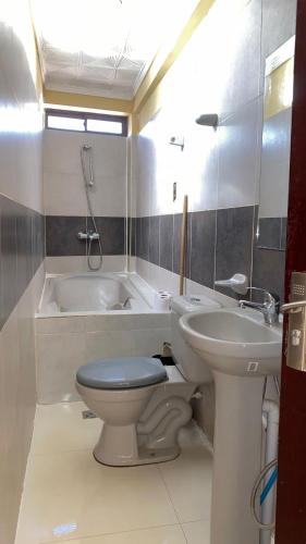 a bathroom with a toilet and a sink and a tub at Hostal Cadena in Tupiza