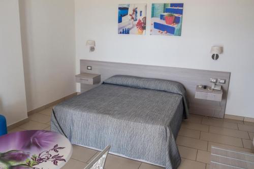 a small bedroom with a bed and a table at Holiday Affittacamere in Corigliano Calabro