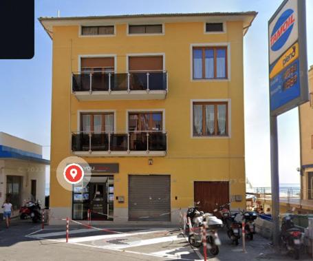 a yellow building with motorcycles parked in front of it at La Risacca in Pietra Ligure