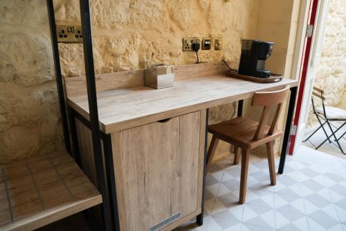un bancone in legno in una stanza con una sedia di No 14 House a Żejtun