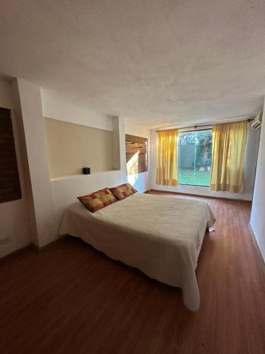ein Schlafzimmer mit großem Bett und Fenster in der Unterkunft Casa Villa Elisa Rio Tercero in Río Tercero