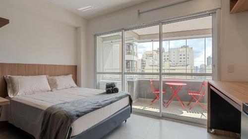 a bedroom with a bed and a balcony with a table at By DH: Luxo e conforto em Perdizes, aos poucos minutos do Allianz parque in Sao Paulo