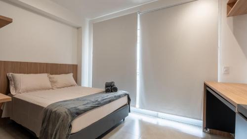 a bedroom with a bed and sliding glass doors at By DH: Luxo e conforto em Perdizes, aos poucos minutos do Allianz parque in Sao Paulo