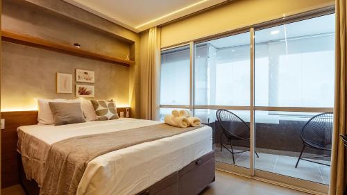 a bedroom with a large bed and a large window at By DH: Luxo e conforto em Perdizes, aos poucos minutos do Allianz parque in Sao Paulo