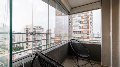 two chairs on a balcony with a view of a city at By DH: Luxo e conforto em Perdizes, aos poucos minutos do Allianz parque in Sao Paulo