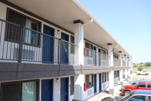 a building with balconies and a red truck parked in a parking lot at Motel 6-Alvin, TX in Alvin