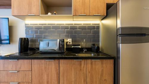 a kitchen with a sink and a microwave at By DH: Luxo e conforto em Perdizes, aos poucos minutos do Allianz parque in Sao Paulo