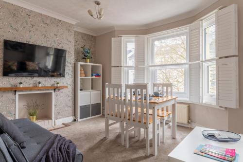 a living room with a table and chairs and a couch at Gorgeous 2-Bed Located in Quiet Area with Nearby Stations in Brighton & Hove