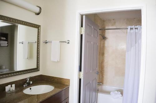 a bathroom with a sink and a shower with a mirror at Staybridge Suites Austin Airport by IHG in Austin
