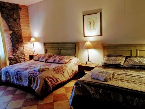 a bedroom with two beds and two tables and lamps at Casona María Esther in San Miguel de Allende