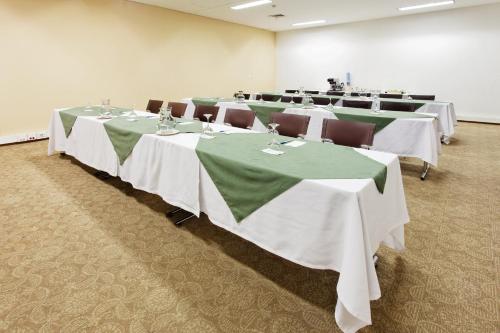 a row of tables in a room with green and white tables at Hotel Holiday Inn Express & Suites Medellin by IHG in Medellín