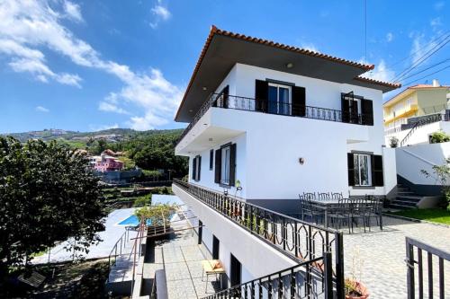 a white house with a balcony and a swimming pool at Viva Village in Gaula