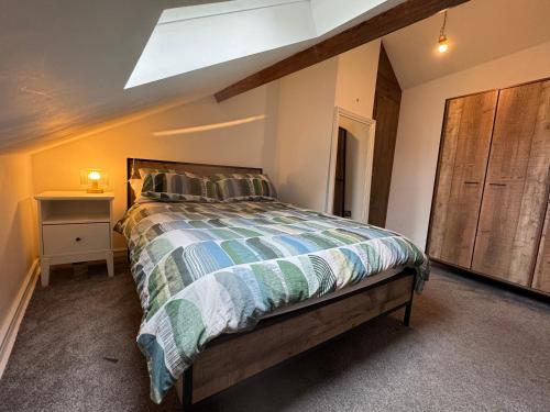 a bedroom with a bed and a wooden cabinet at Contactless Check In - Spacious New-York Style Penthouse Apartment in Leeds City Centre in Leeds