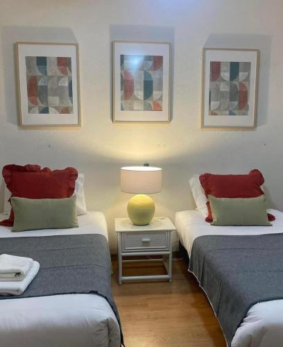 a room with two beds and a table with a lamp at Mar Sereno Praia Formosa in Funchal
