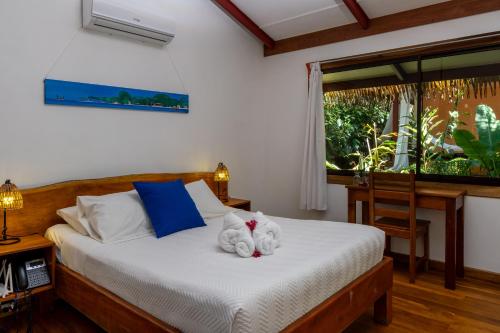 a bedroom with a bed with two stuffed animals on it at Namuwoki Lodge in Puerto Viejo