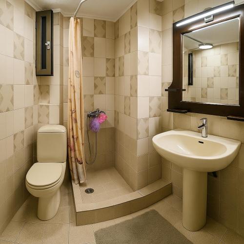 a bathroom with a toilet a sink and a shower at Billy's Place in Egina