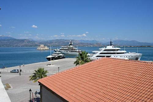 two boats are docked in a harbor with a red roof at Porto Nafplio in Nafplio