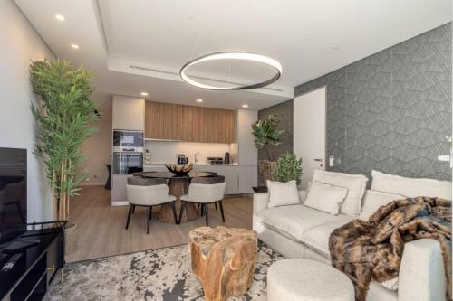 a living room with a white couch and a table at Infinity Haven in Funchal
