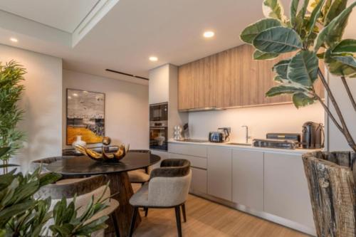 a kitchen with white cabinets and a table and chairs at Infinity Haven in Funchal