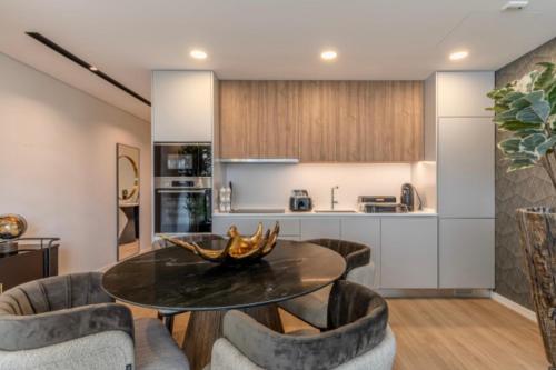 a kitchen and living room with a table and chairs at Infinity Haven in Funchal