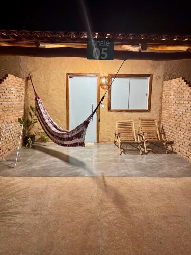 a patio with two chairs and a hammock in a building at Chalés da Chapada in Carolina