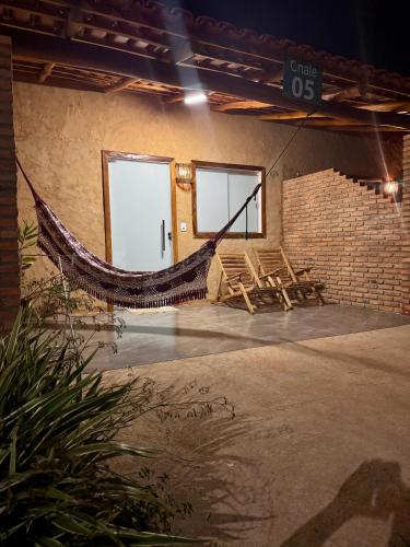 a room with a hammock and a brick wall at Chalés da Chapada in Carolina
