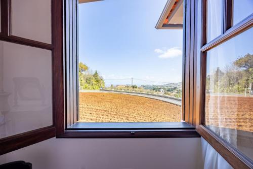 a window with a view of a field outside at Silva Retreat Villa in São Jorge