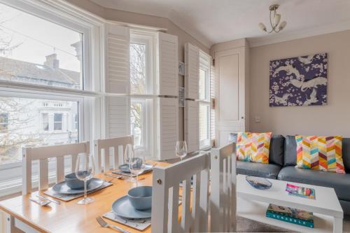 a dining room with a table and a couch at Gorgeous 2-Bed Located in Quiet Area with Nearby Stations in Brighton & Hove