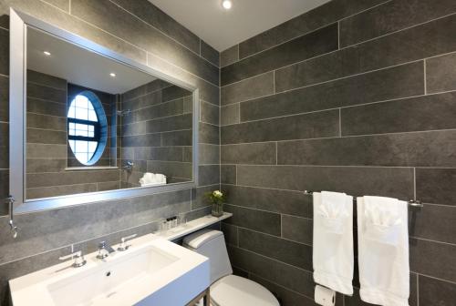 a bathroom with a sink and a toilet and a mirror at Fitzpatrick Grand Central in New York