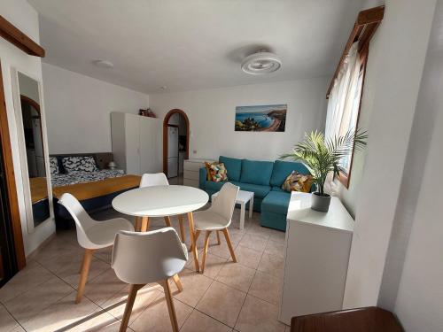 a living room with a blue couch and a table and chairs at Sun Studio Tenerife in Arona