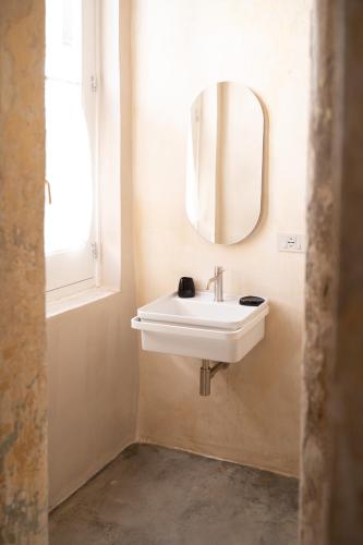 a bathroom with a white sink and a mirror at Fundacari B&b in Gallipoli