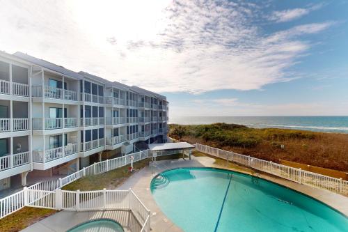 an apartment building with a swimming pool and the ocean at Dunescape Villas 252 in Atlantic Beach