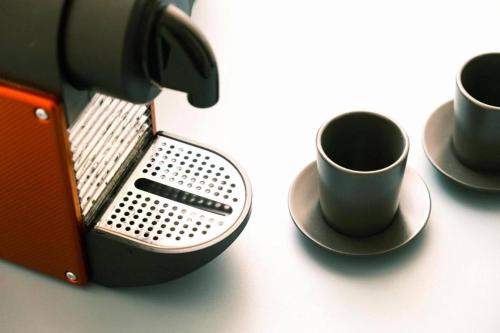 three coffee cups on a table next to a coffee machine at ComeCasa Turin Nest 2 Bedroom Comfort in Turin