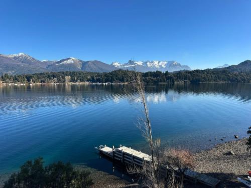 a dock in the middle of a lake with mountains at Suite del muelle in San Carlos de Bariloche