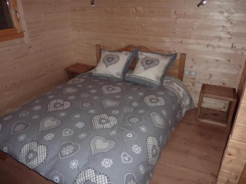 Un dormitorio con una cama en una cabaña de troncos en Les Noisettes, en La Bresse
