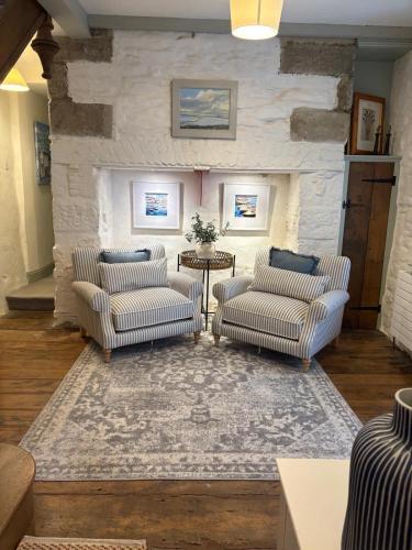 a living room with two chairs and a table at Merchants House in Penryn