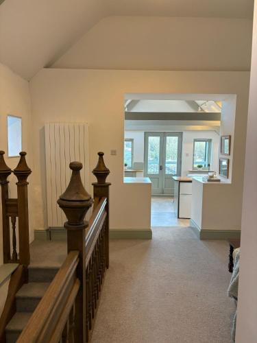 a living room with a staircase and a kitchen at Merchants House in Penryn