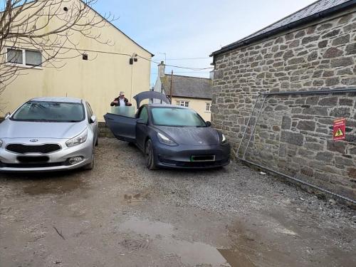two cars parked in a parking lot next to a building at Merchants House in Penryn