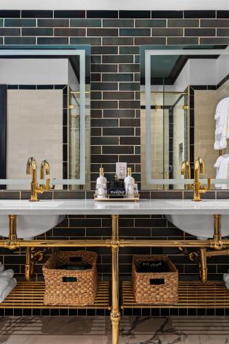 a bathroom with two sinks and two mirrors at Emigrant Boutique Hotel in Fredericksburg