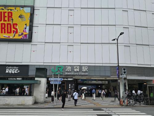 a city street with people walking in front of a building at SLEEPLAB THE STAY 池袋 -Ikebukuro- in Tokyo