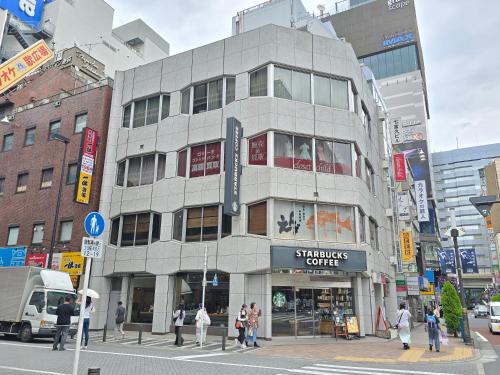 a building on a city street with people walking around it at SLEEPLAB THE STAY 池袋 -Ikebukuro- in Tokyo